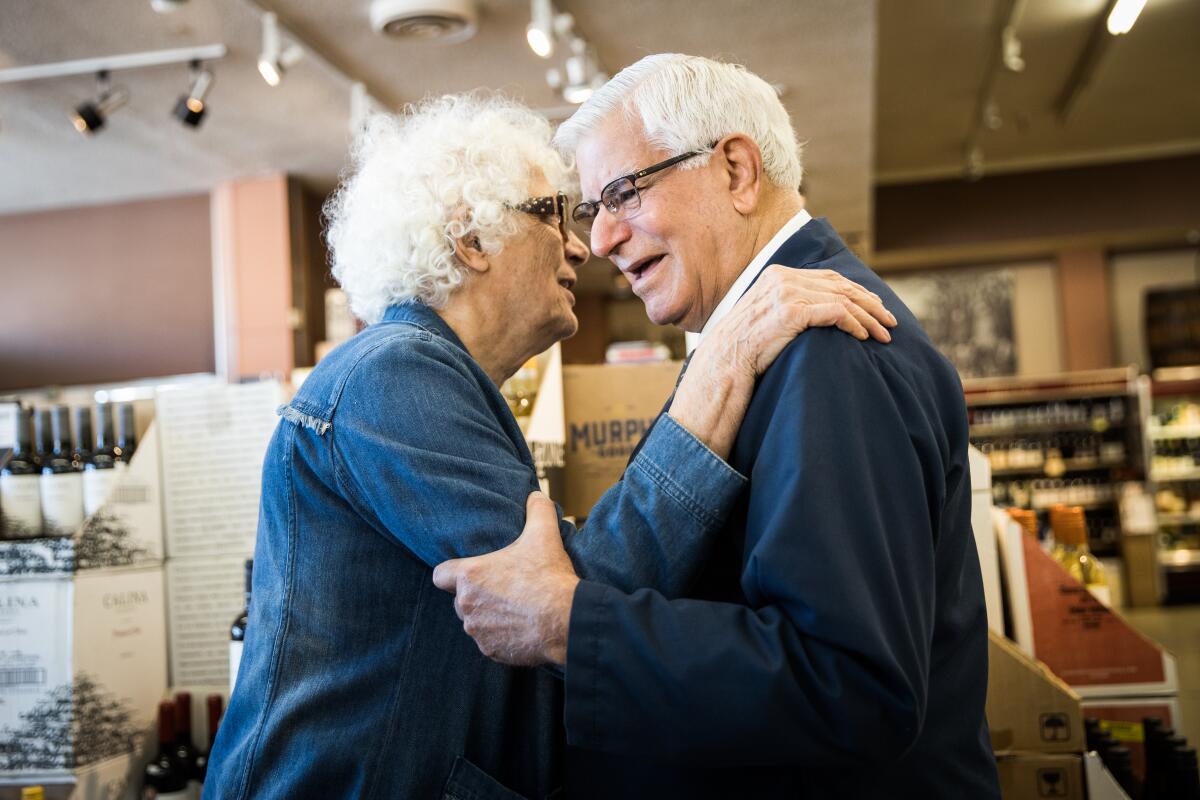 A customer embraces grocer Darrell Corti, right, at Corti Brothers grocery store in Sacramento.