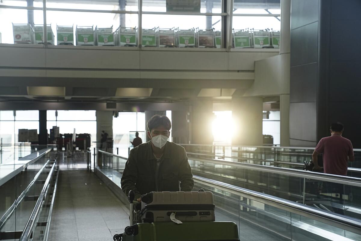 Passenger with luggage cart at Hong Kong's international airport