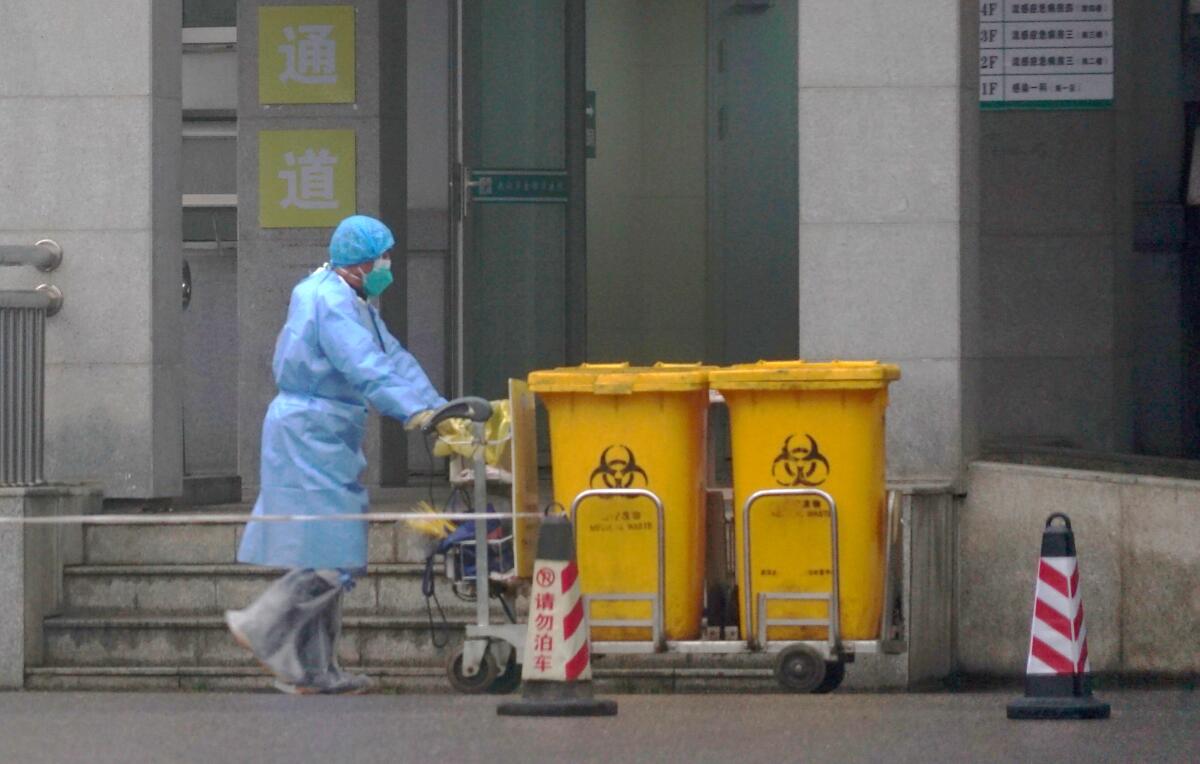 A person pushes bio-waste containers.