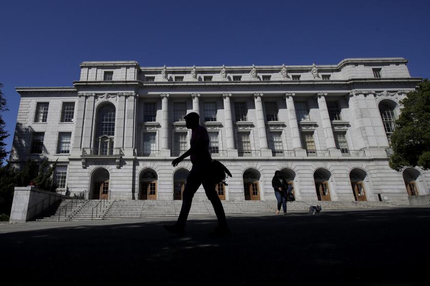 People walk in front of Wheeler Hall on the University of California campus in Berkeley, Calif., Wednesday, March 11, 2020. UC Berkeley has suspended in-person classes due to coronavirus concerns. (AP Photo/Jeff Chiu)