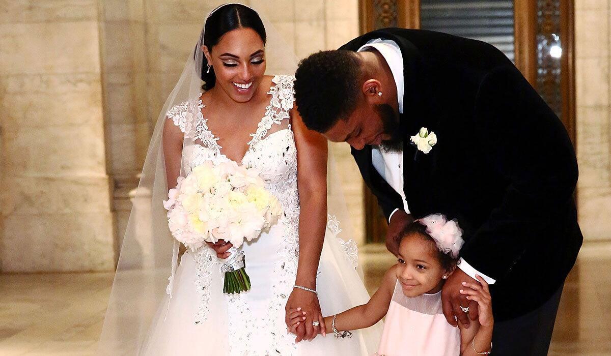 Asha Joyce and Devon Still pose after their wedding ceremony with 6-year-old Leah Still.