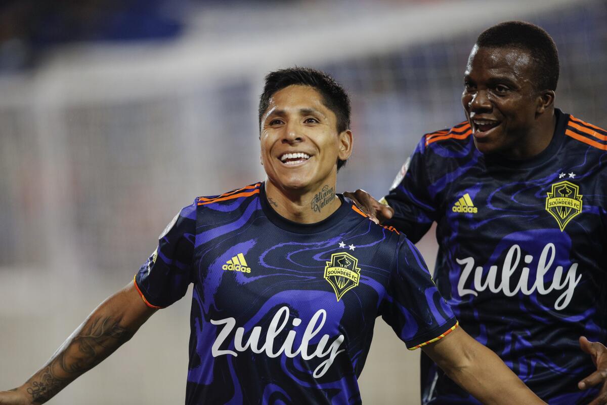 Seattle Sounders forward Raul Ruidiaz (9) celebrates his goal with defender Nouhou Tolo (5) during the first half against New York City FC in the second leg of a CONCACAF Champions League soccer semifinal, Wednesday, April 13, 2022, in Harrison, N.J. (AP Photo/Eduardo Munoz Alvarez)