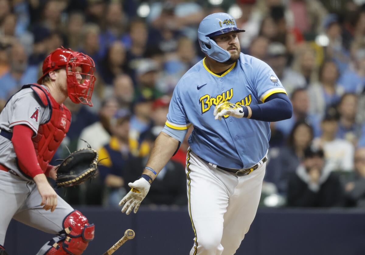 The Brewers' Rowdy Tellez hits a go-ahead, RBI single during the eighth inning as Angels catcher Chad Wallach watches.