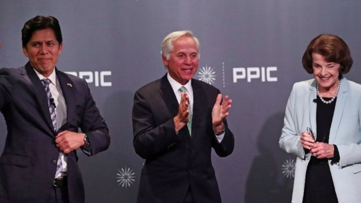 Mark Baldassare, center, of the Public Policy Institute of California, applauds at the end of the debate he moderated between state Sen. Kevin de León (D-Los Angeles) and U.S. Sen. Dianne Feinstein on Wednesday in San Francisco.