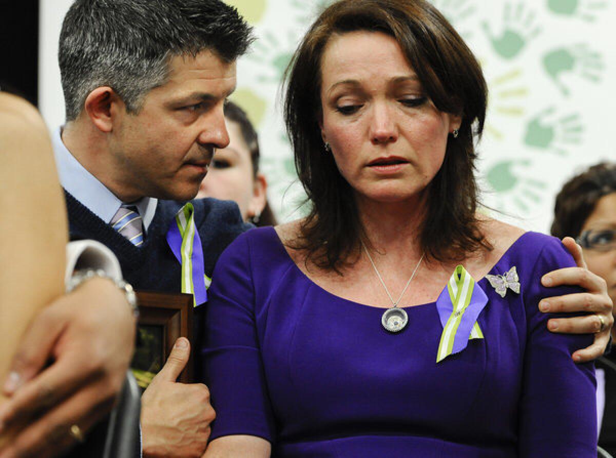 Ian and Nicole Hockley, parents of Sandy Hook school shooting victim Dylan, listen at a news conference at Edmond Town Hall in Newtown, Conn., on the one-month anniversary of the massacre.