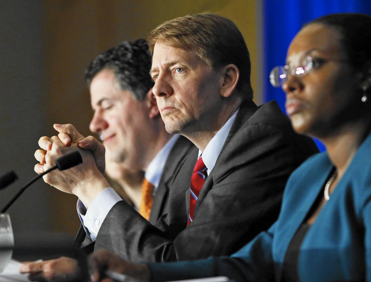 Consumer Financial Protection Bureau Director Richard Cordray, center, listens to comments during a panel discussion in Richmond, Va.