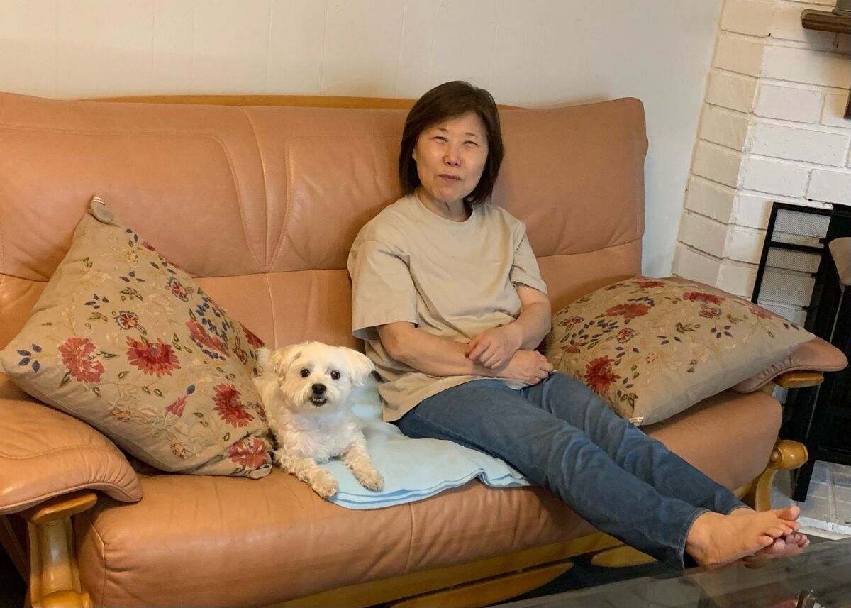 Yongja Lee, 65, with the family dog, Cory