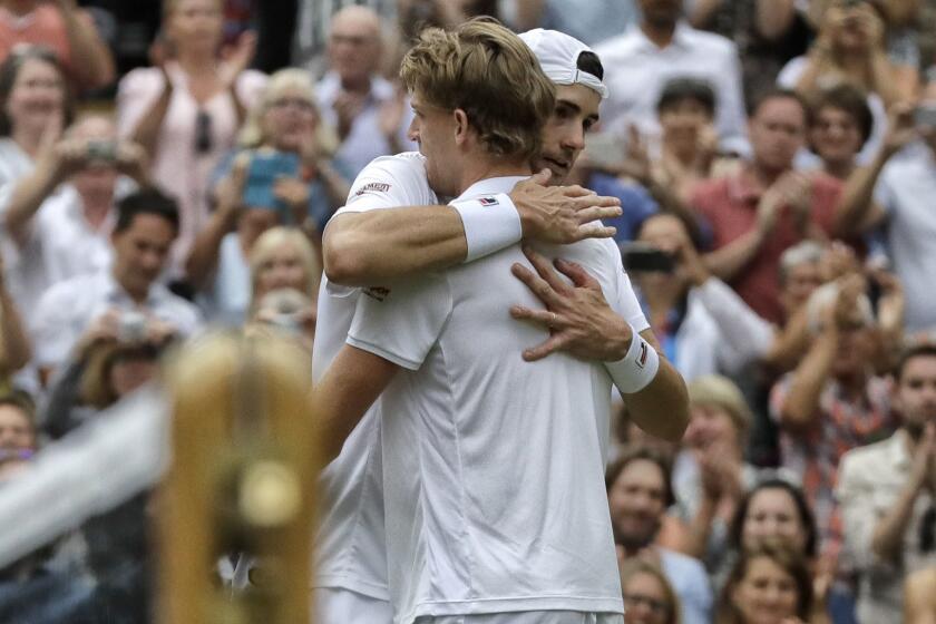 South Africa's Kevin Anderson hugs John Isner of the United States, right, after defeating him in their men's singles semifinals match at the Wimbledon Tennis Championships, in London, Friday July 13, 2018.(AP Photo/Kirsty Wigglesworth)