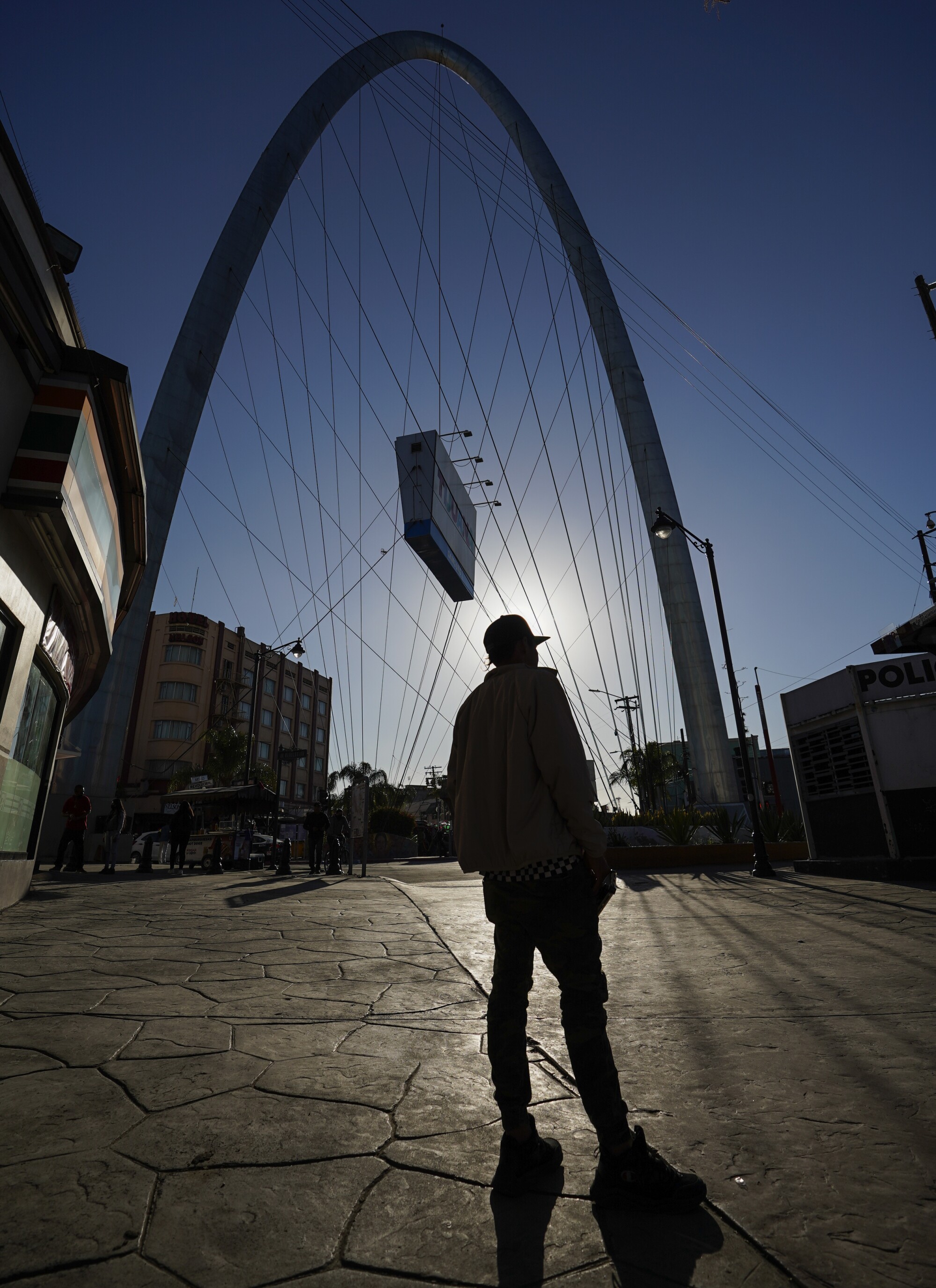 A man is silhouetted in front of Tijuana's famous arch