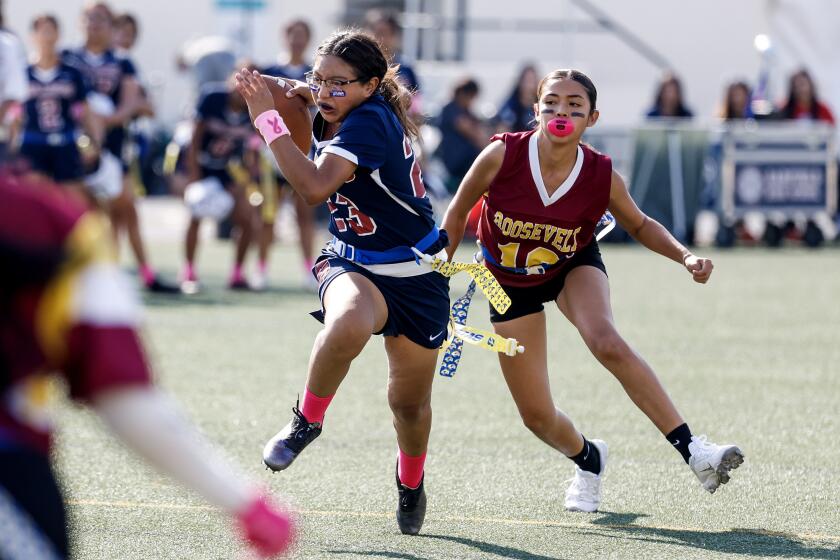 Los Angeles, CA - October 27: Garfield Bulldogs' Gisselle Galicia (L) runs pas Roosevelt Rough Riders' Maya Padilla during the East L.A. Classic Girls Flag Football Game at East Los Angeles College Weingart Stadium on Friday, Oct. 27, 2023 in Los Angeles, CA. (Ringo Chiu / For De Los)
