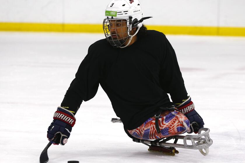 IRVINE, CALIF. - AUG. 17, 2019. Ralph DeQuebec, a Paralympic hockey gold medalist from Harbor City, participates in a sled hockey clinicat Great Park Ice rinks in Irvine on Saturday, Aug. 17, 2019. DeQuebec is a former Marine who lost both legs above the knee due to an injury he suffered in Afghanistan. The Anaheim Ducks of the NHL sponsor a program that allows disabled people to play sled hockey. (Luis Sinco/Los Angeles Times)