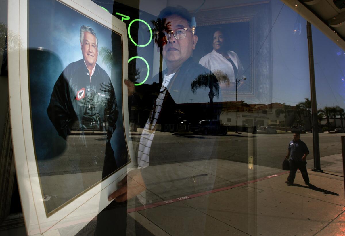 Gary Miyatake, a Japanese American photographer, places his portrait of Cesar Chavez in the display window at his studio in Gardena. The portrait will be donated to the Smithsonian.