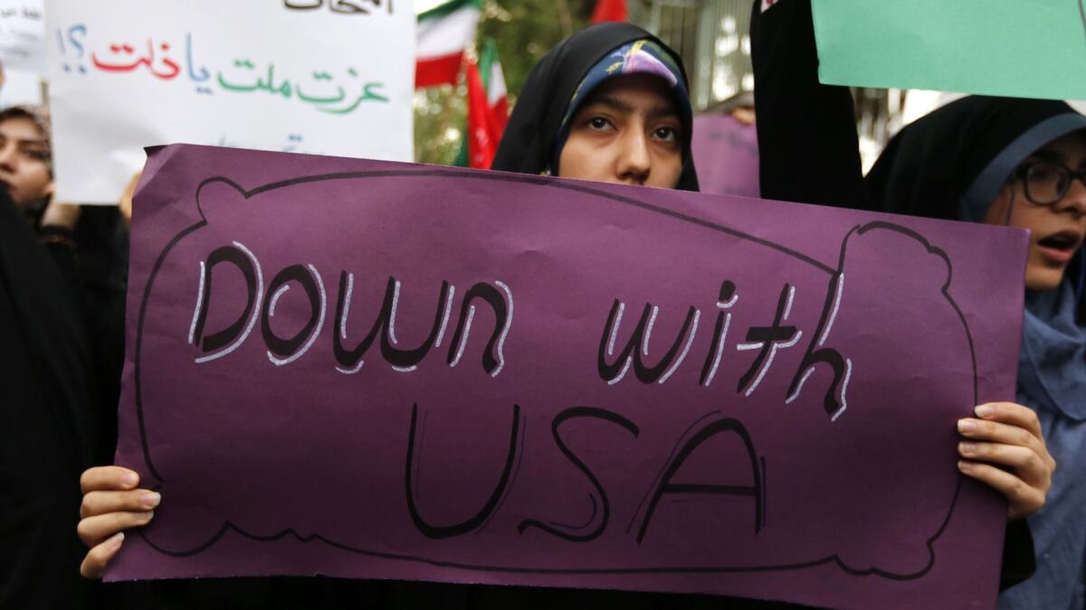 Iranian women carry anti-U.S. signs during a demonstration outside the former American embassy in Tehran on May 9.