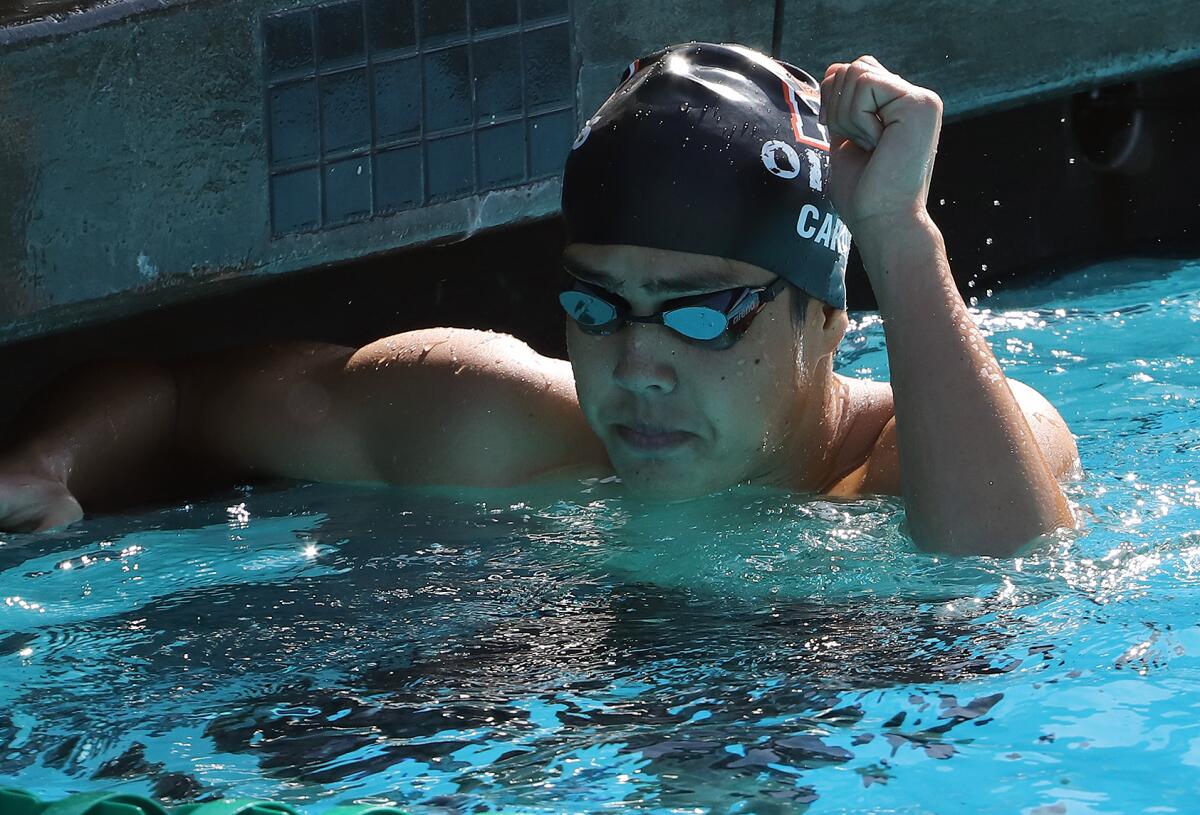 Huntington Beach's Jun Caruso celebrates with a fist bump after winning the 200 IM during the Surf League swim finals Friday.