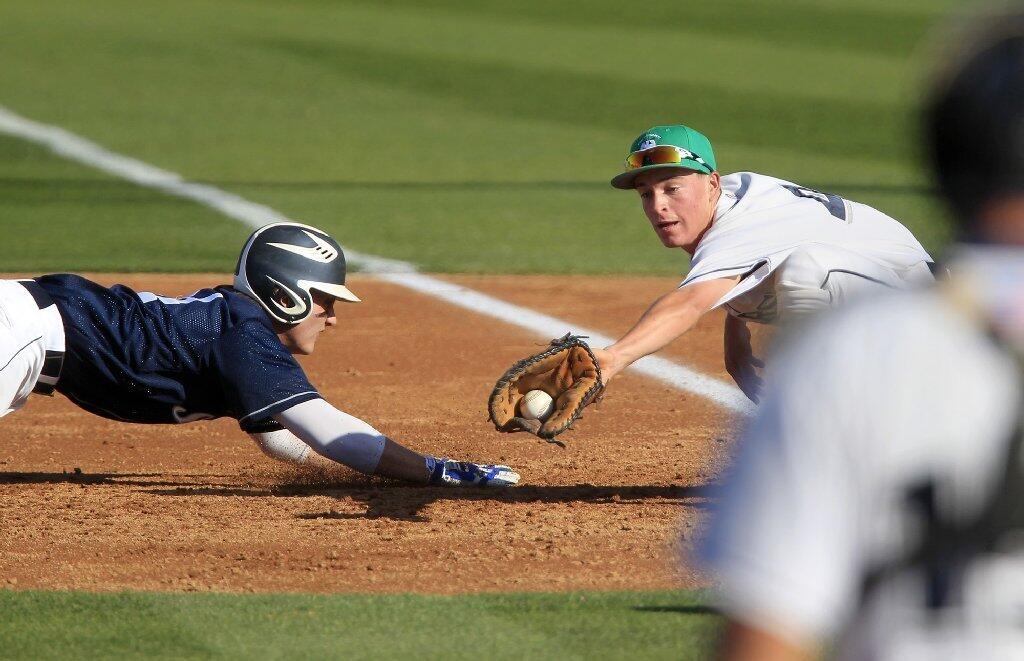 Newport Harbor High's Jake Genova, right, completes a double play with this out at first base on Corona del Mar's Nick Premer, left, during the second inning of Game 1 in the Battle of the Bay doubleheader at Anteater Ballpark on Monday.