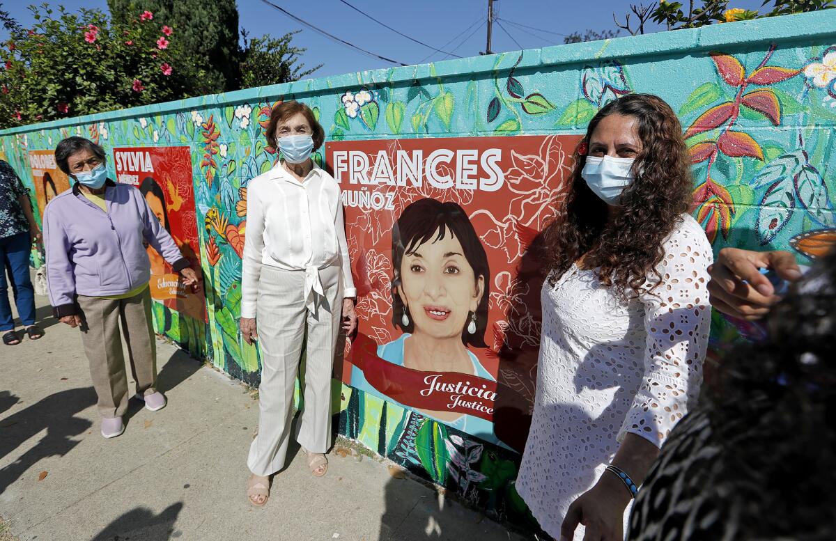 Cristina Prada and Frances Munoz, from left, with artist Alicia Rojas at a 2020 mural dedication in Costa Mesa.