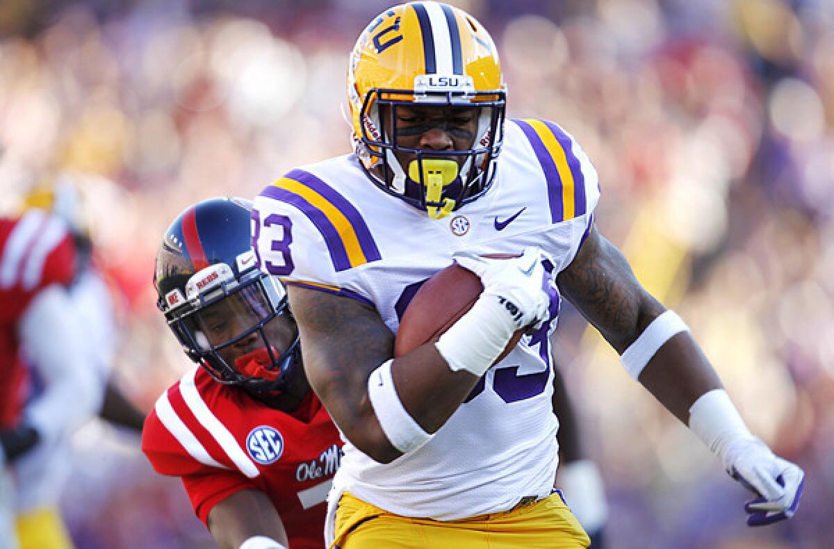 LSU running back Jeremy Hill gets past Mississippi defensive back Trae Elston for a 27-yard touchdown run last season.