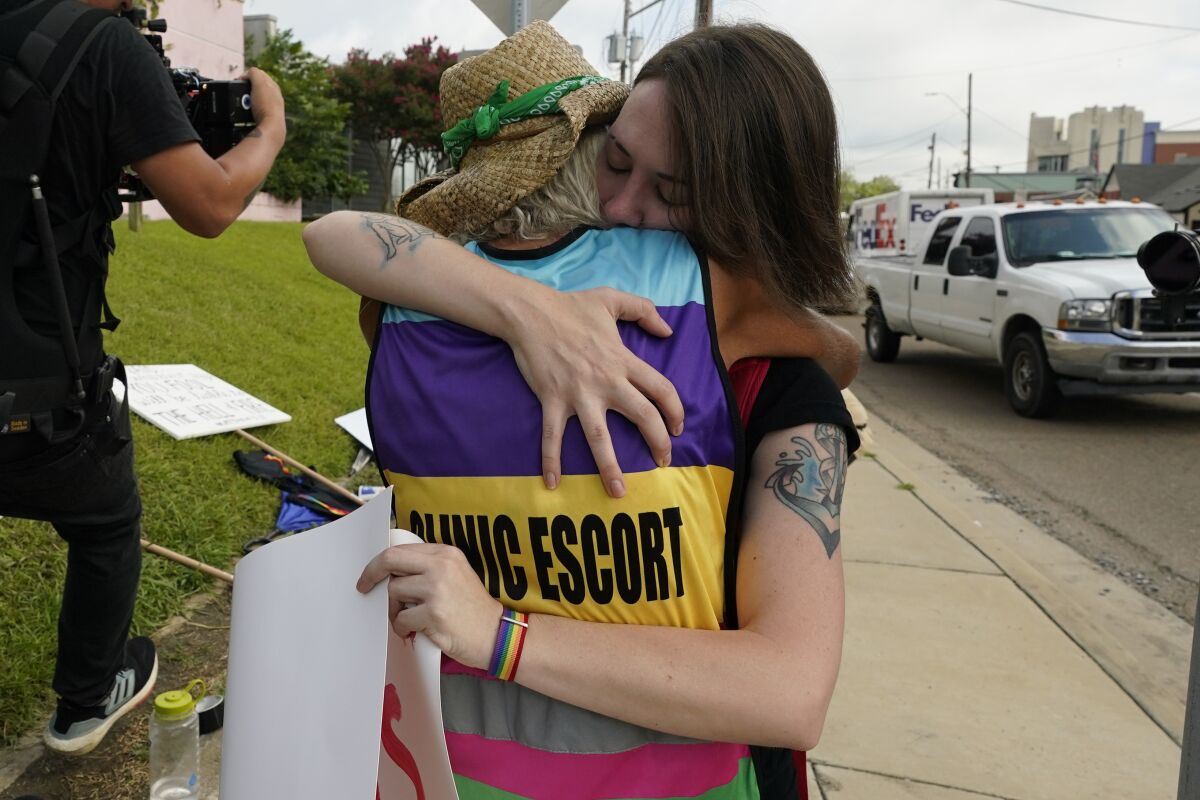 Two people hug in front of an abortion clinic in Mississippi.