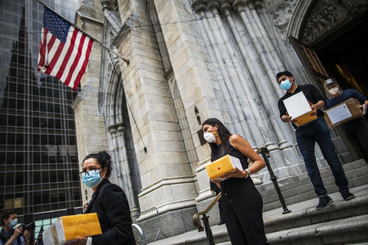 Mourners carry out the remains of loved ones who died from COVID-19, at St. Patrick's Cathedral in New York.