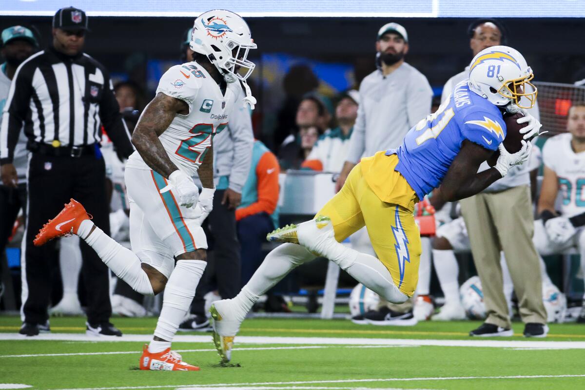 Chargers receiver Mike Williams falls to the turf after catching a pass as Dolphins cornerback Xavien Howard pursues.
