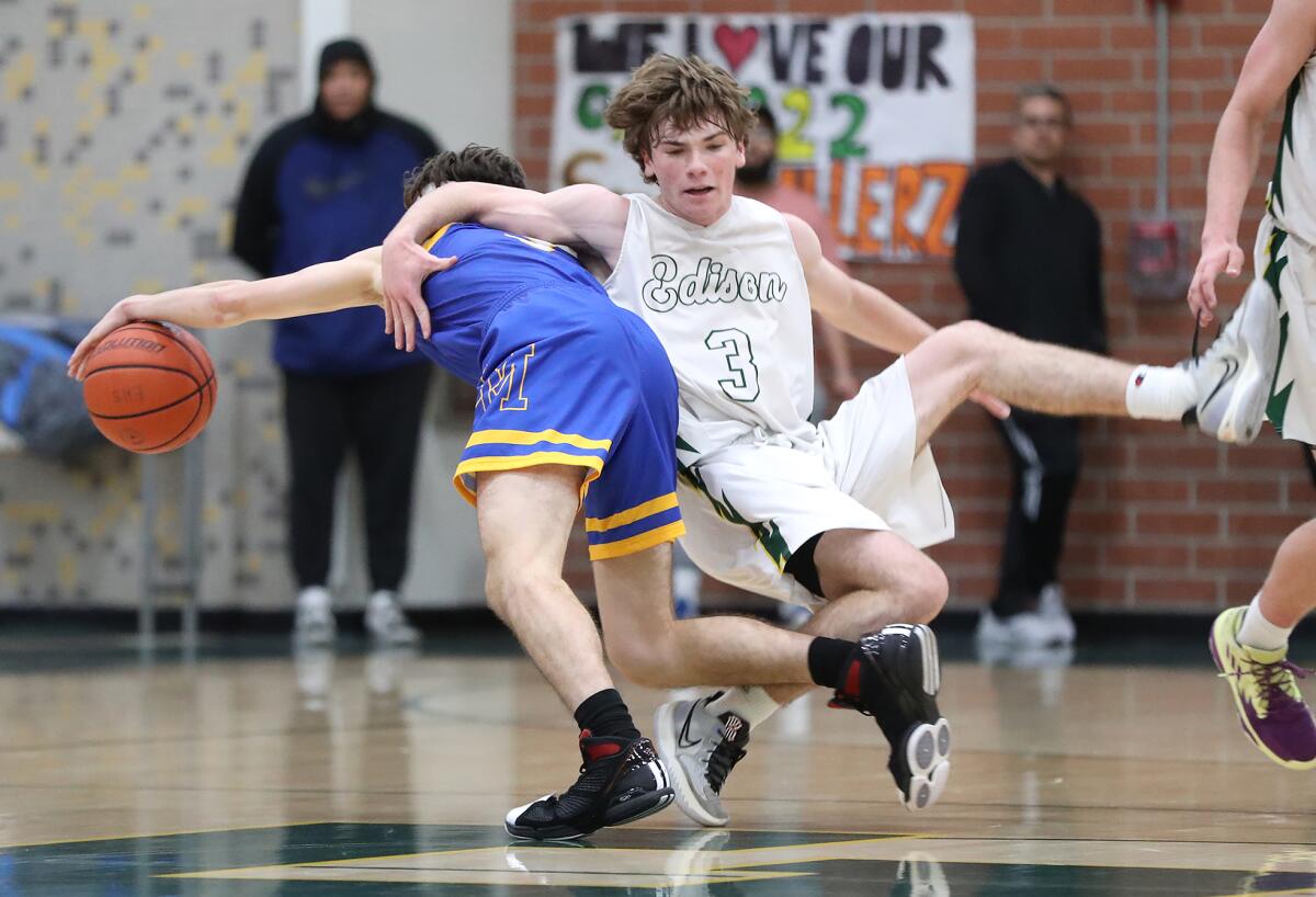 Edison's Quinn Delaney (3) gets tangled up with Julien Gomez (3) of La Mirada as he dribbles to the basket.