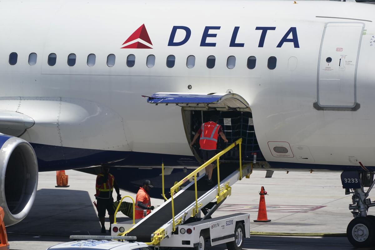 FILE - Workers unload a Delta Air Lines Airbus A320 at the Fort Lauderdale-Hollywood International Airport in Fort Lauderdale, Fla., on Thursday, July 7, 2022. One day after placing a big order with Boeing, Delta said Tuesday, July 19, 2022, it has ordered 12 more jets from Airbus, Boeing's European rival. (AP Photo/Wilfredo Lee, File)