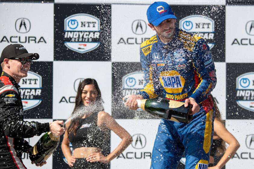 Long Beach Grand Prix winner Alexander Rossi, right, is sprayed with champagne by runner-up Josef Newgarden.