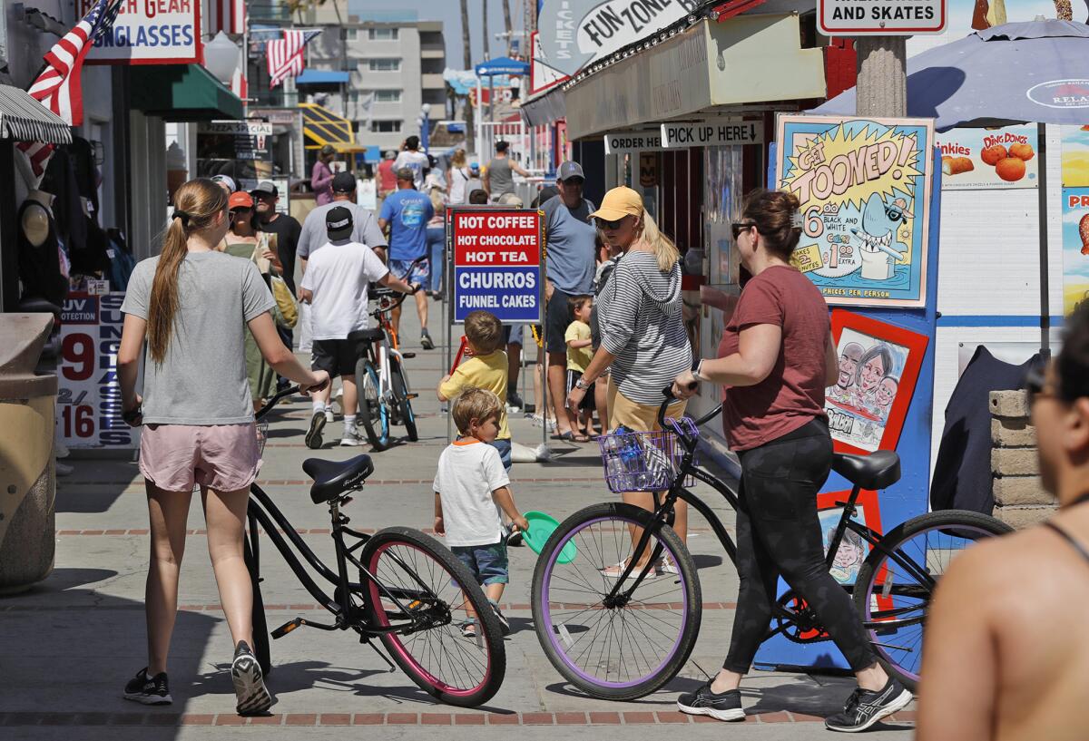 Visitors enjoy the Newport Beach Fun Zone. Health officials say COVID-19 cases are rising in Orange County.