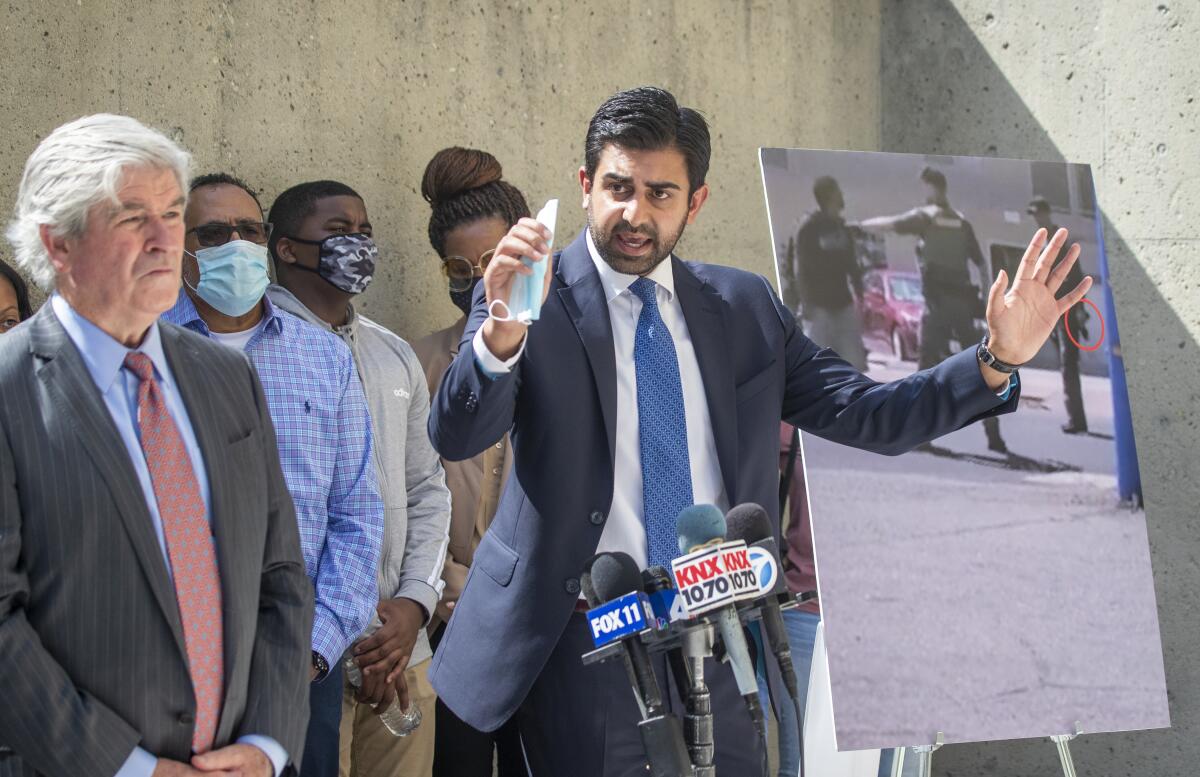 Neil Gehlawat, right, lawyer for the Reinhold family, speaks at a news conference in Santa Ana.