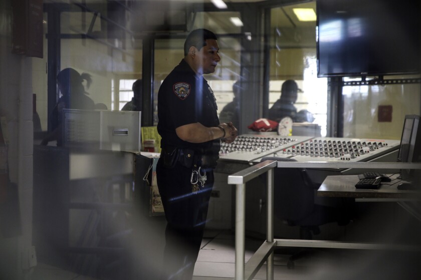 FILE - A corrections officer watches monitors at a security post in an enhanced supervision jail unit on Rikers Island in New York, on March 12, 2015. New York City’s troubled jail system is facing more turmoil: the suspension of hundreds of corrections officers for failing to meet a Tuesday night, Nov. 30, 2021, deadline to get vaccinated against COVID-19. The city’s Department of Correction reported 77% of its uniformed staff had gotten at least one vaccine dose as of 5 p.m. Monday, Nov. 29 (AP Photo/Seth Wenig, File)