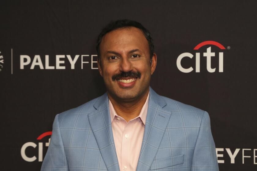 Rizwan Manji smiling in a blue suit