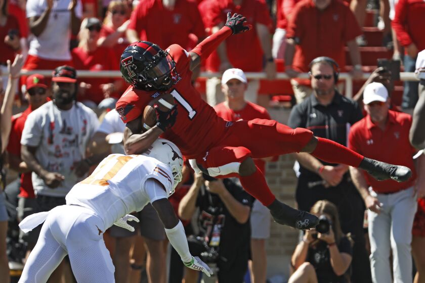 Texas' Anthony Cook (11) tackles Texas Tech's Myles Price (1) during the first half of an NCAA college football game Saturday, Sept. 24, 2022, in Lubbock, Texas. (AP Photo/Brad Tollefson)