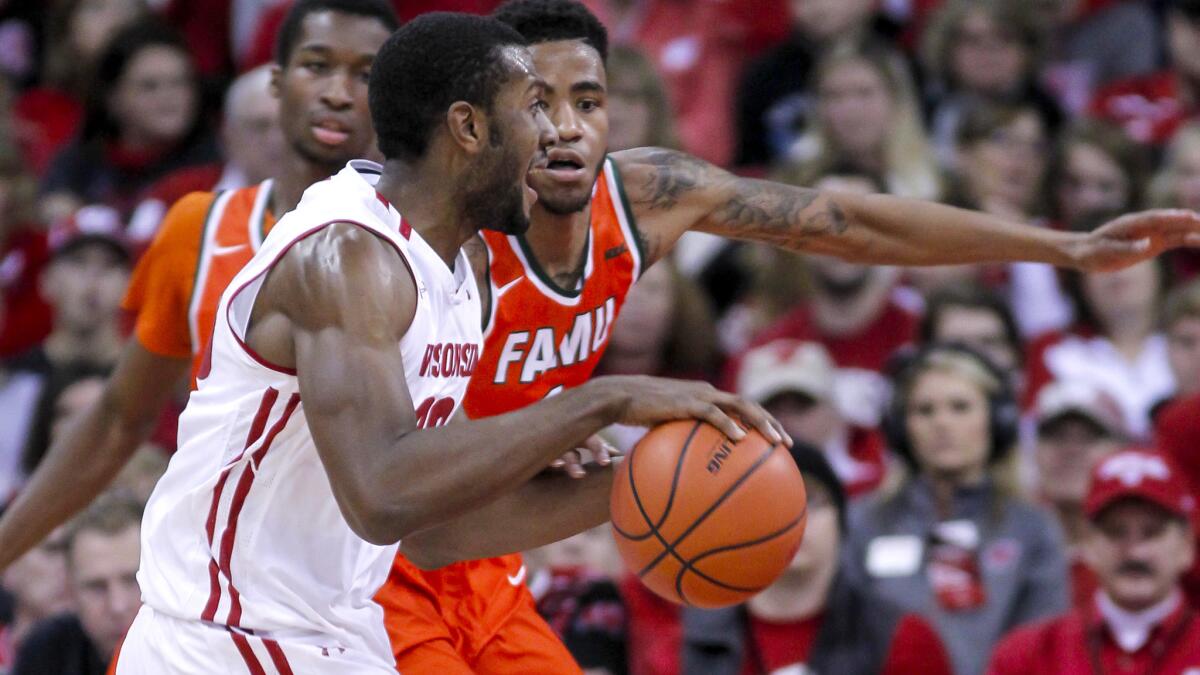 Florida A&M's Nick Severado, behind, reaches in on Wisconsin's Vitto Brown during the first half of an NCAA college basketball game Friday, Dec. 23, 2016, in Madison, Wis. (AP Photo/Andy Manis)