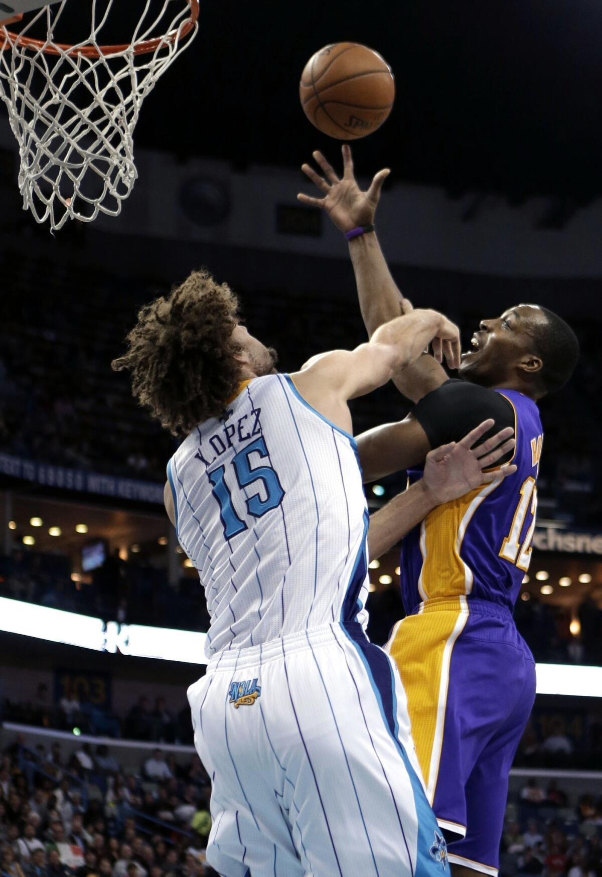 Lakers center Dwight Howard powers a shot past Hornets center Robin Lopez.
