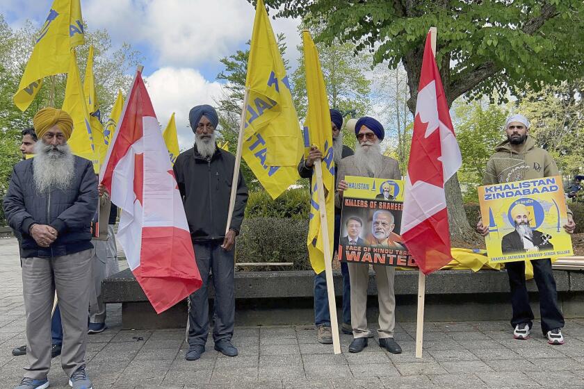 Members of British Columbia's Sikh community gather in front of the courthouse in Surrey, British Columbia, Tuesday, May 7, 2024. Three men accused of murdering temple leader Hardeep Singh Nijjar made their first court appearance by video. (Chuck Chiang/The Canadian Press via AP)