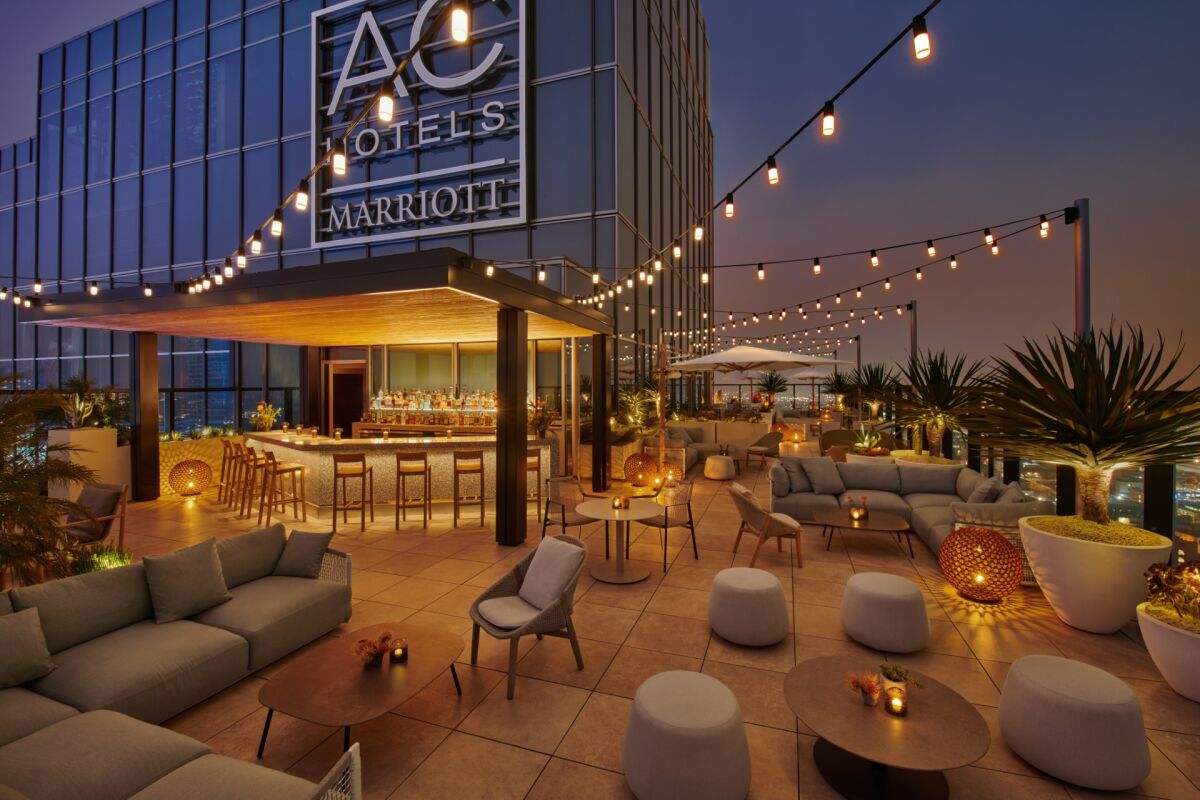 A rooftop bar with big "AC Hotels Marriot" sign and strings of lights