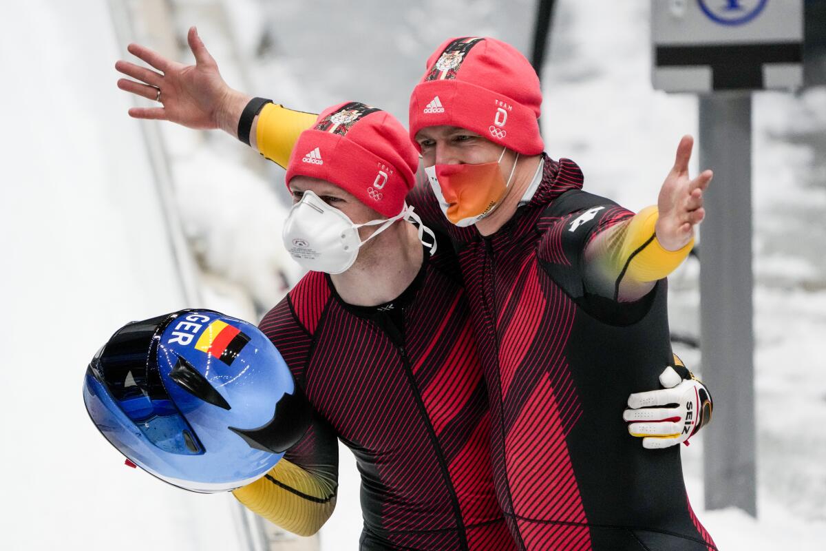 Francesco Friedrich and Thorsten Margis of Germany celebrate after winning the gold medal in the two-man bobsled.