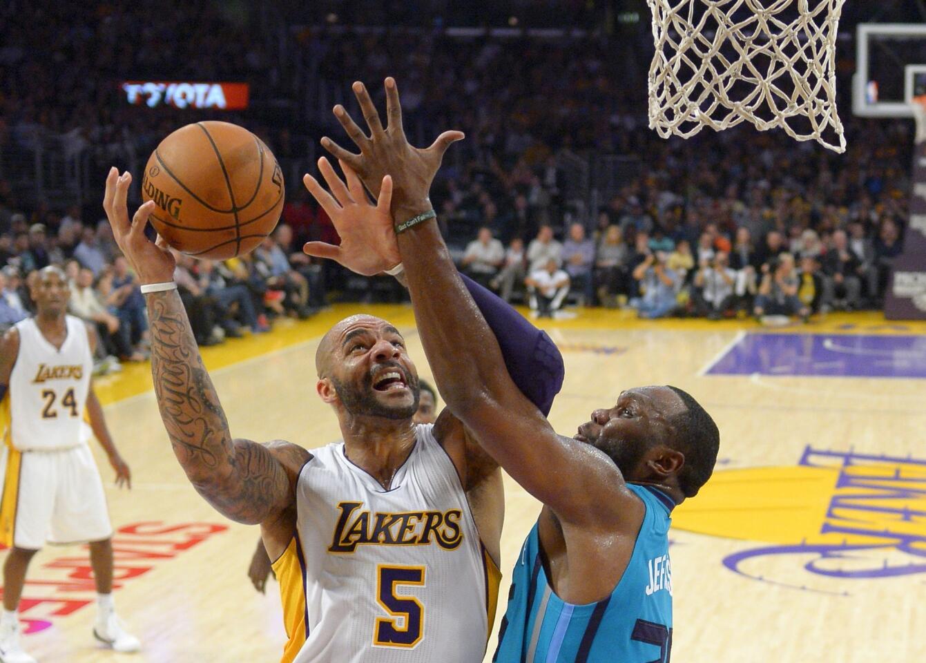 Lakers power forward Carlos Boozer goes to the basket against Charlotte Hornets center Al Jefferson during a game at Staples Center on Nov. 9. The Lakers won, 107-92.