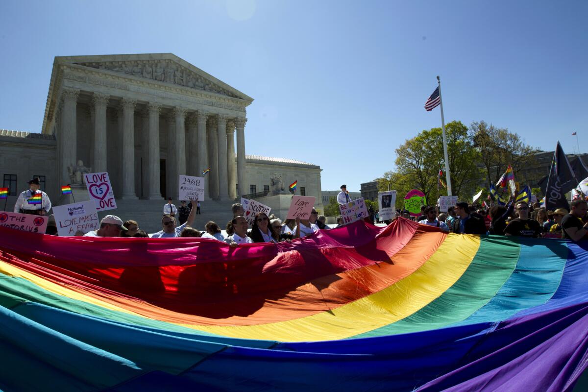 Manifestantes se paran frente a la Corte Suprema en Washington con una bandera del arcoíris para escuchar argumentos históricos en casos sobre el matrimonio del mismo sexo. (Foto AP/José Luis Magaña, archivo)