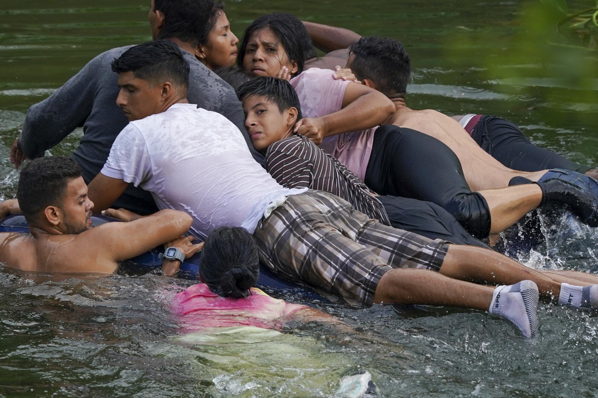 Migrants cross the Rio Grande on an inflatable mattress into the United States from Matamoros, Mexico.
