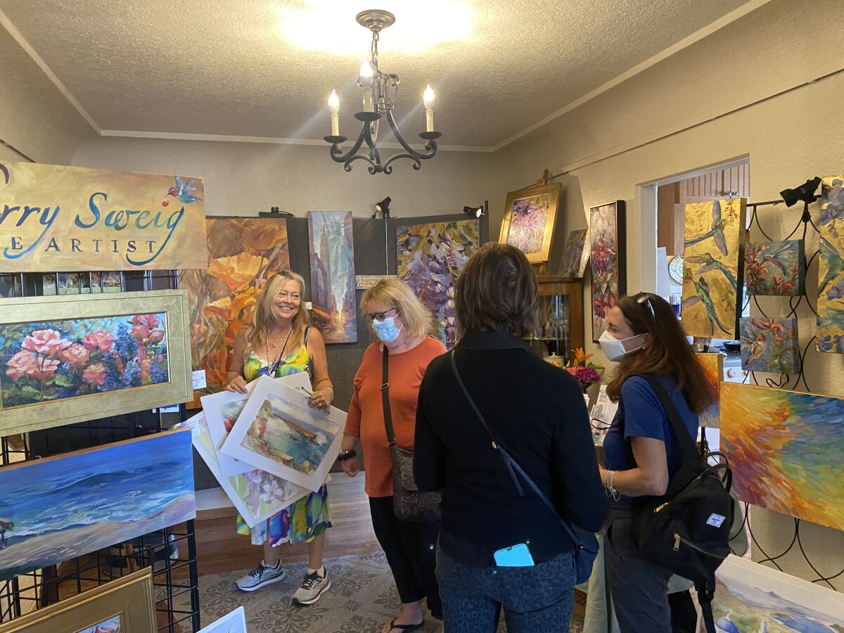 La Jolla painter Cherry Sweig (left) shows her art to visitors during the Sept. 18 San Diego Coastal Art Studios Tour.