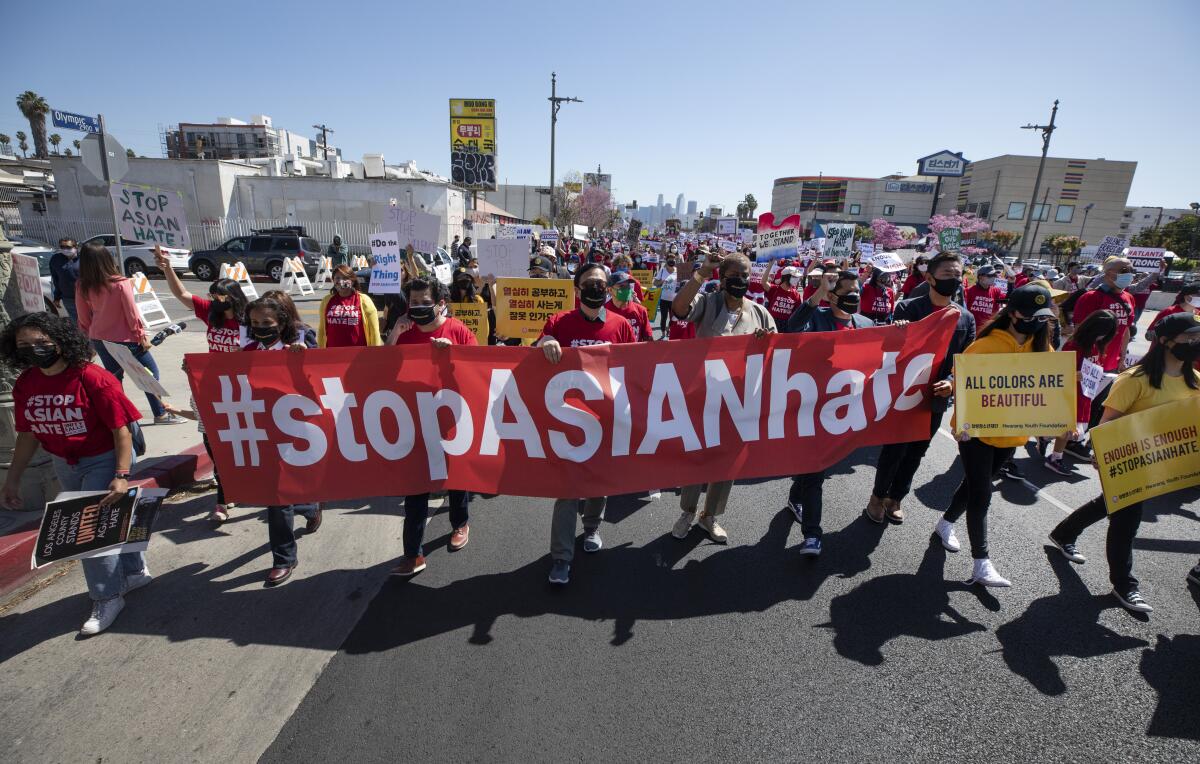 People hold a banner at a "Stop Asian Hate" rally.