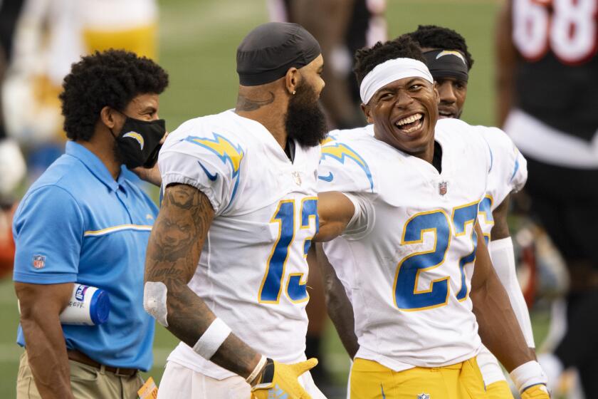 Los Angeles Chargers running back Joshua Kelley (27) and wide receiver Keenan Allen (13) celebrate their 16-13 win over the Cincinnati Bengals during an NFL football game, Sunday, Sept. 13, 2020, in Cincinnati. (AP Photo/Emilee Chinn)