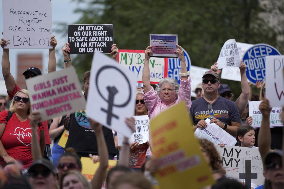 Protesters hold signs reading "My Body, My Choice" and "Keep Abortion Legal."