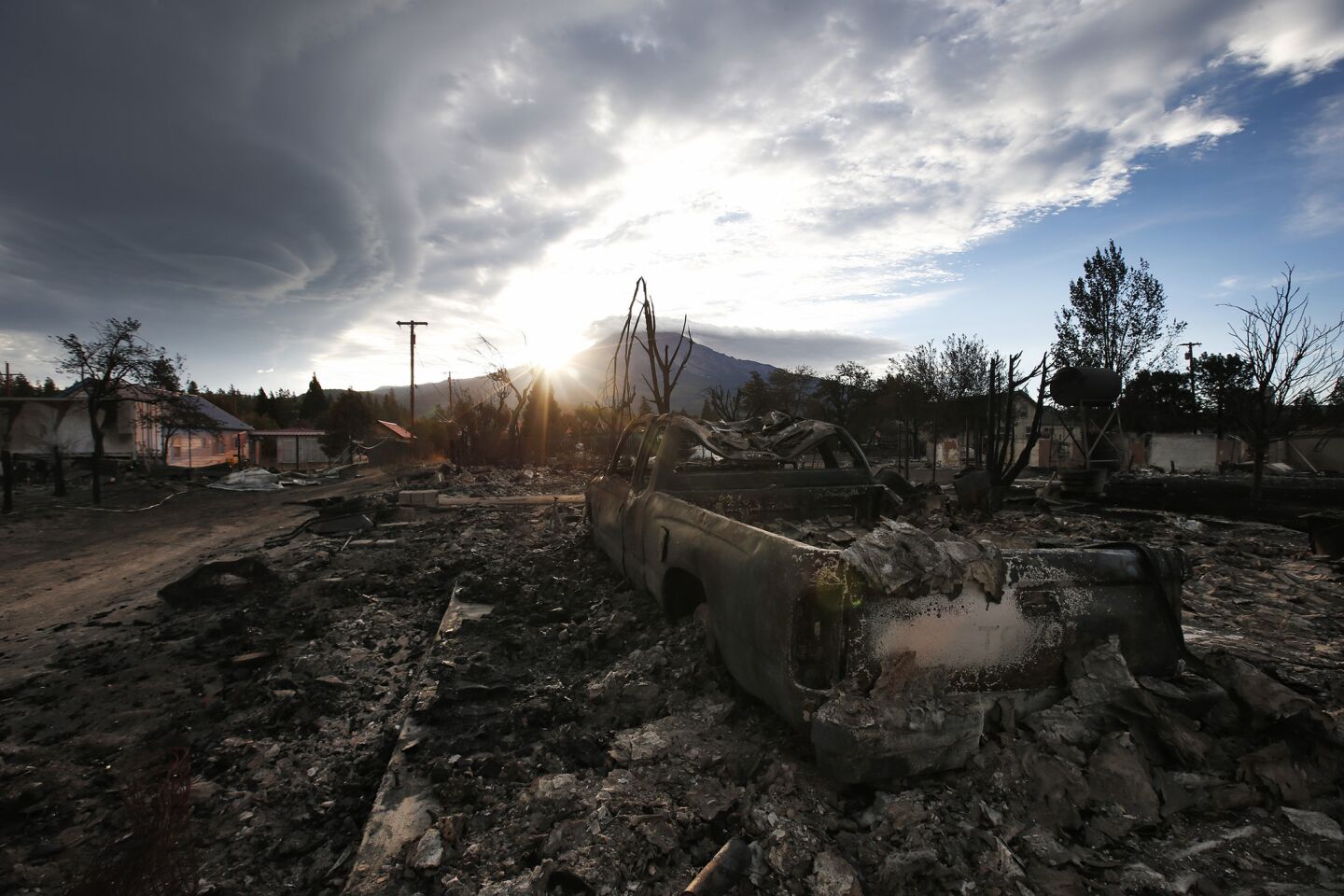 The sun rises behind Mt. Shasta overlooking the devastated Angel Valley neighborhood two days after the Boles Fire, pushed by heavy winds devastated this town near the California and Oregon border.