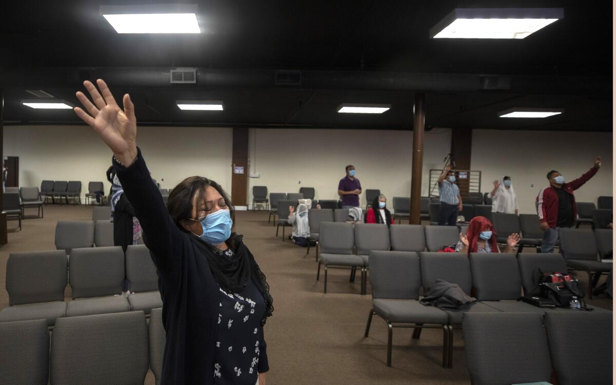 A woman holds up her right arm during a worship gathering.