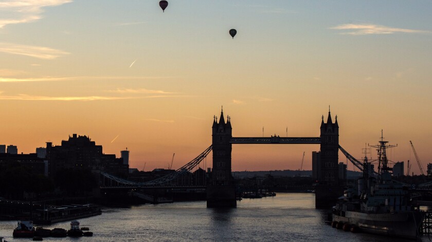 Two hot air balloons fly over Tower Bridge on the River Thames as dawn breaks and the sun rises over the British capital. Travel to London has become less expensive since Brexit, a survey has found.