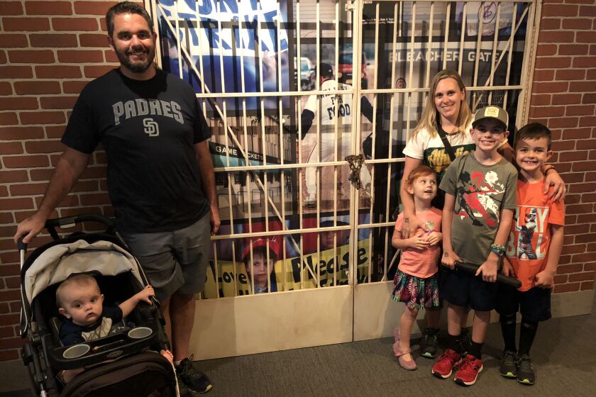 Erin States Hoy and family take a photo near the Baseball Hall of Fame display about the 1994 strike, which features a photo of her as a 10-year-old girl.