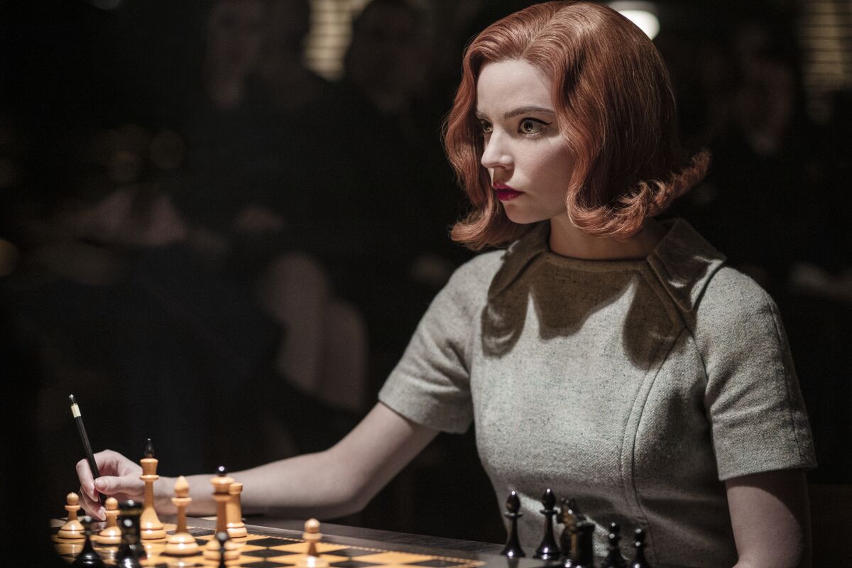 Anya Taylor-Joy sits in front of a chessboard in her role in "The Queen's Gambit."