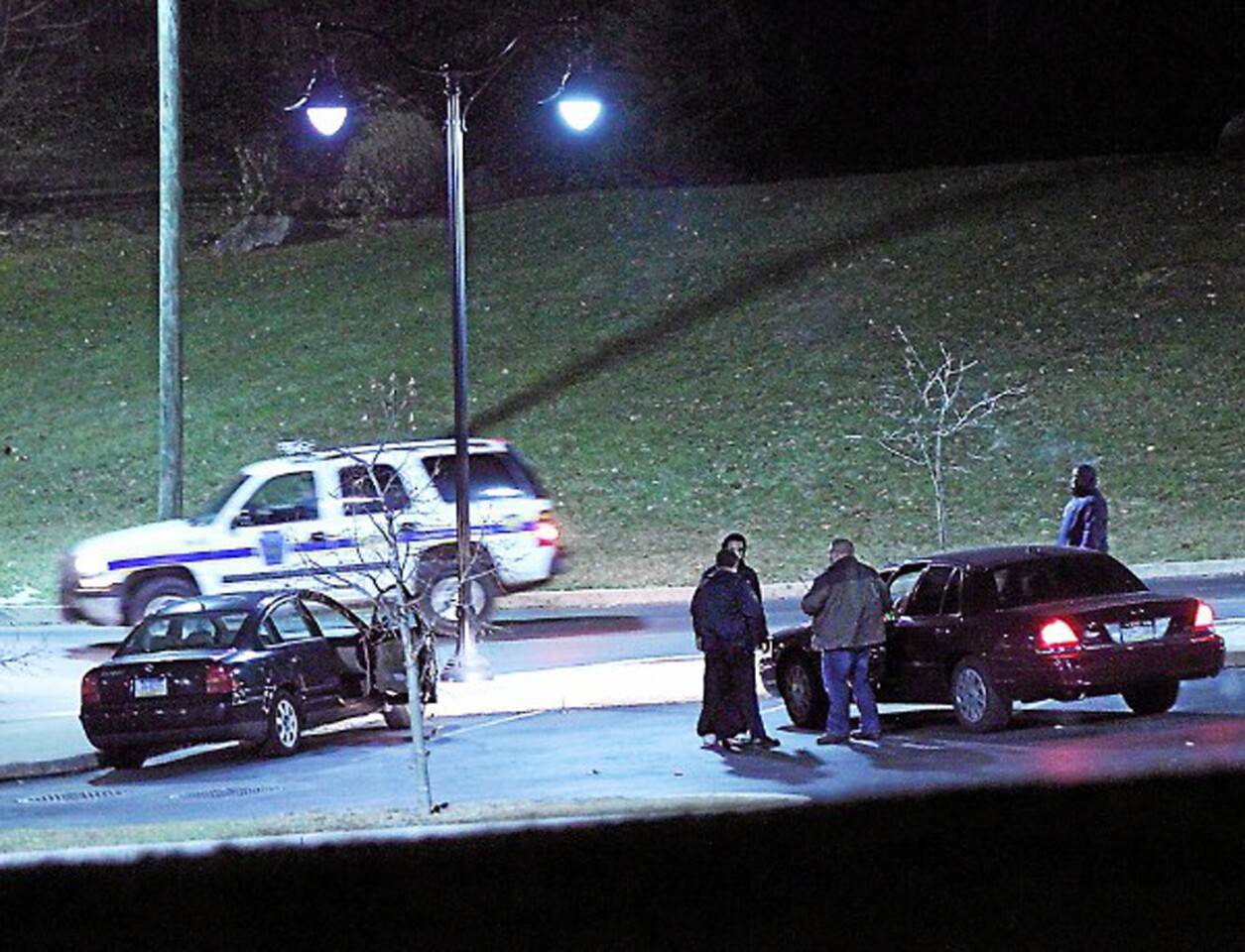 Police investigate a car, left, at the athletic center of Widener University in Chester, Pa., after a student was shot Monday.